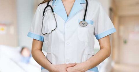 Front view of nurses' middle of body with patient in blurred in background