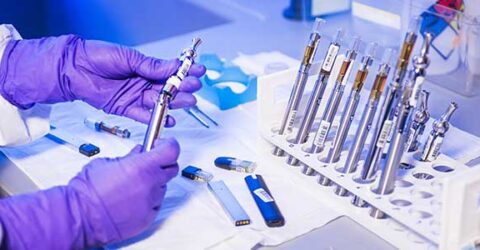 Person's hands in lab working with test tube samples